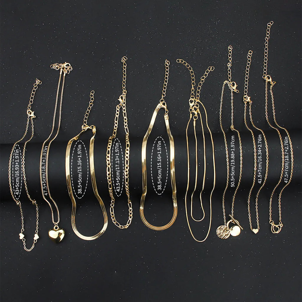 Set of 10 gold women's necklaces with adjustable chains and alloy pendants displayed in gift packaging