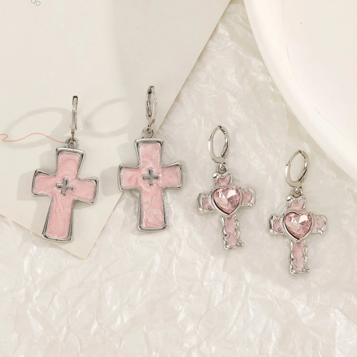 Women's classic alloy earrings showing cross, heart, and animal designs in white, black, and silver colours