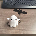 Small hand-painted resin statue of a ghost walking a dog and holding a bat, a miniature Halloween ornament.