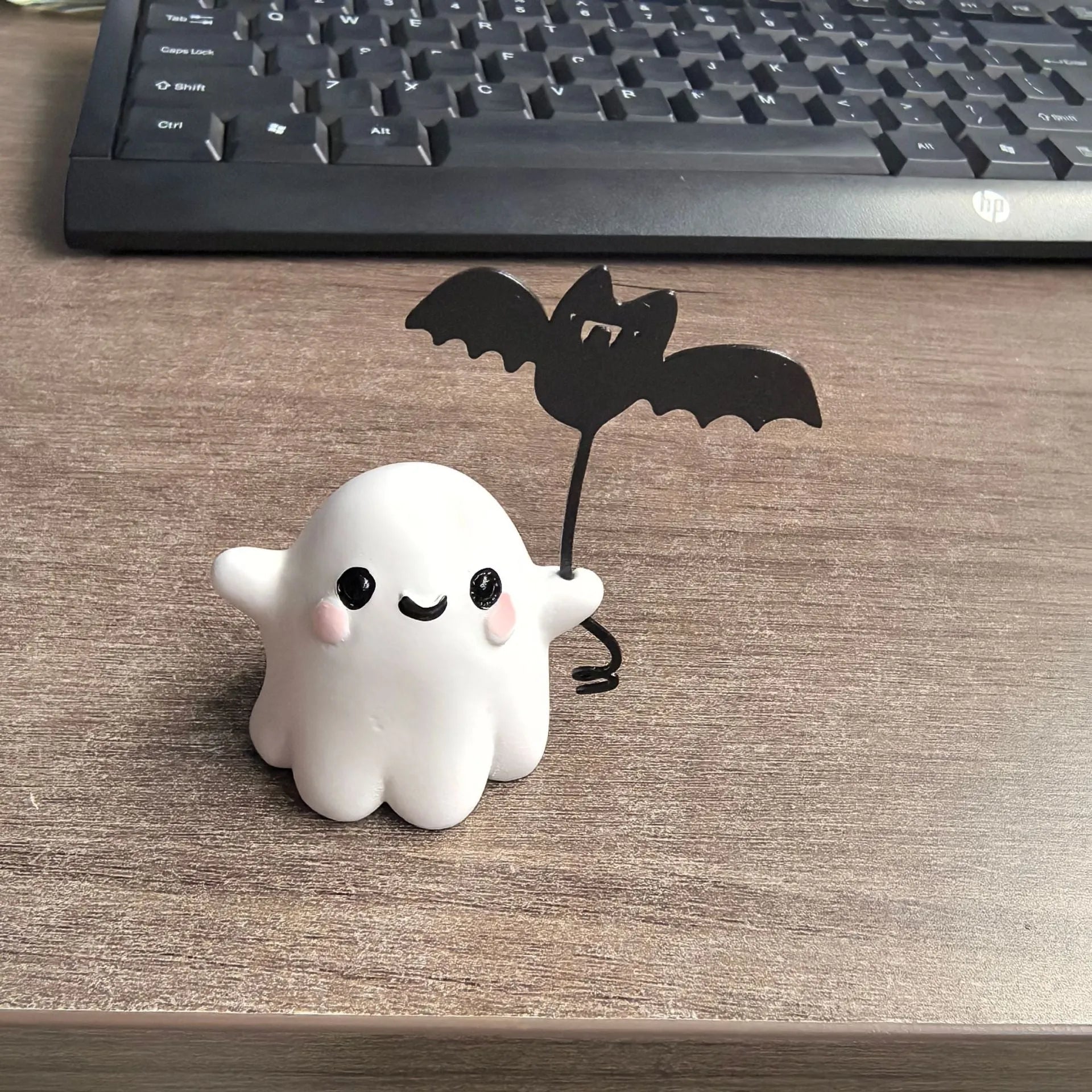 Small hand-painted resin statue of a ghost walking a dog and holding a bat, a miniature Halloween ornament.