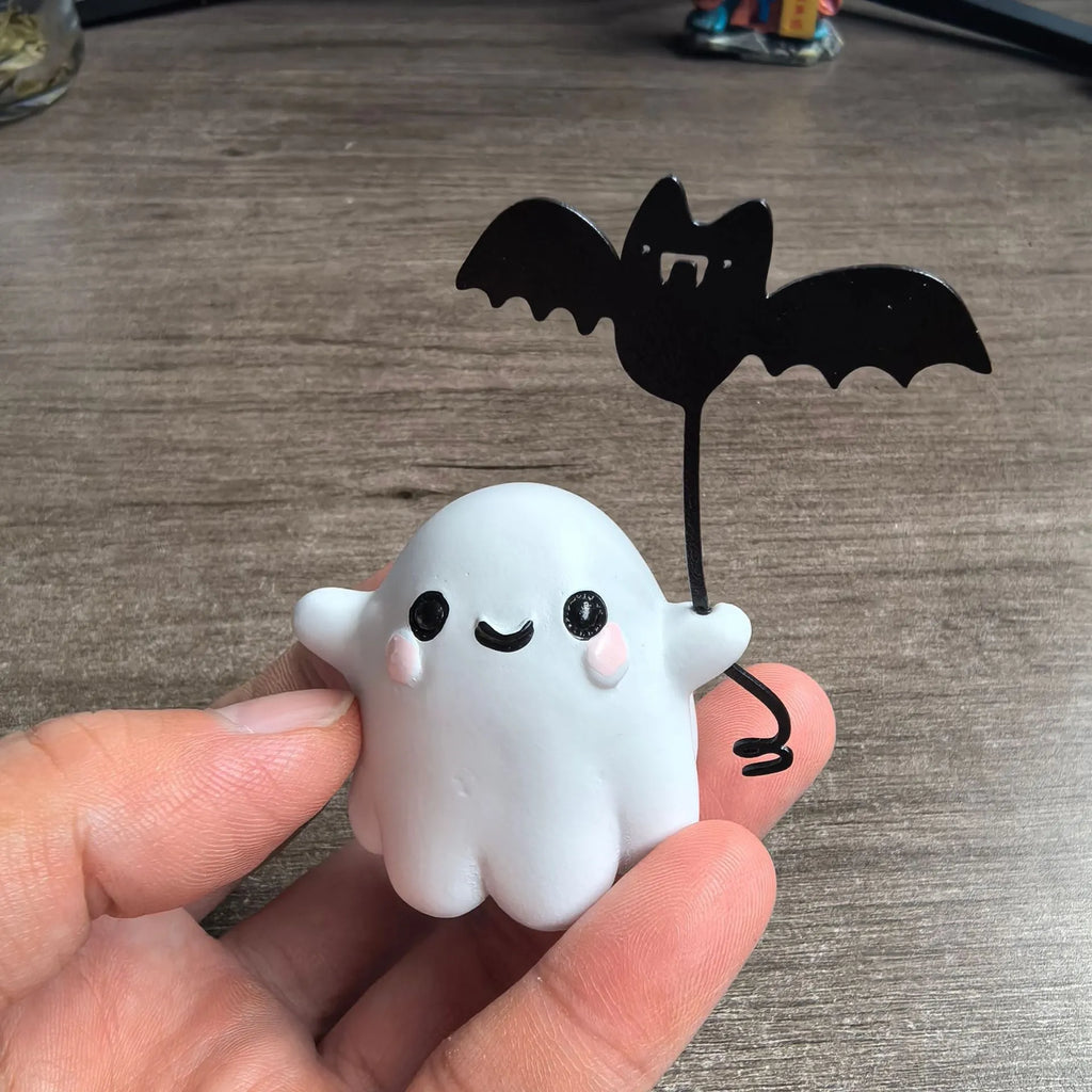 Small hand-painted resin statue of a ghost walking a dog and holding a bat, a miniature Halloween ornament.