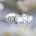 White electroplated alloy women's ring in a heart shape with a flower opal ocean design on its face.