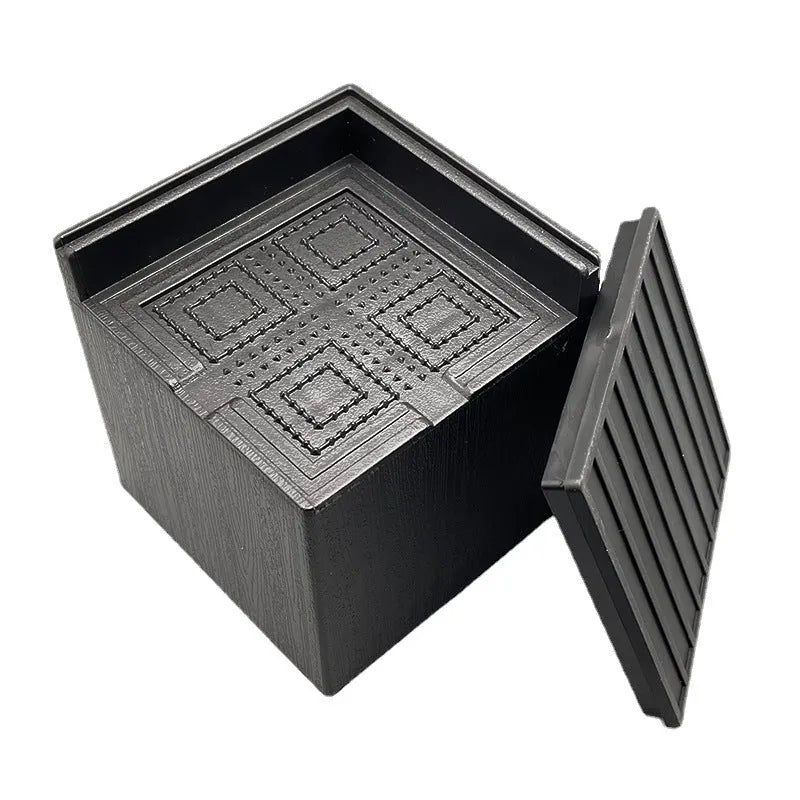 Four black plastic furniture foot mats for raising bed or sofa legs on hard floors.