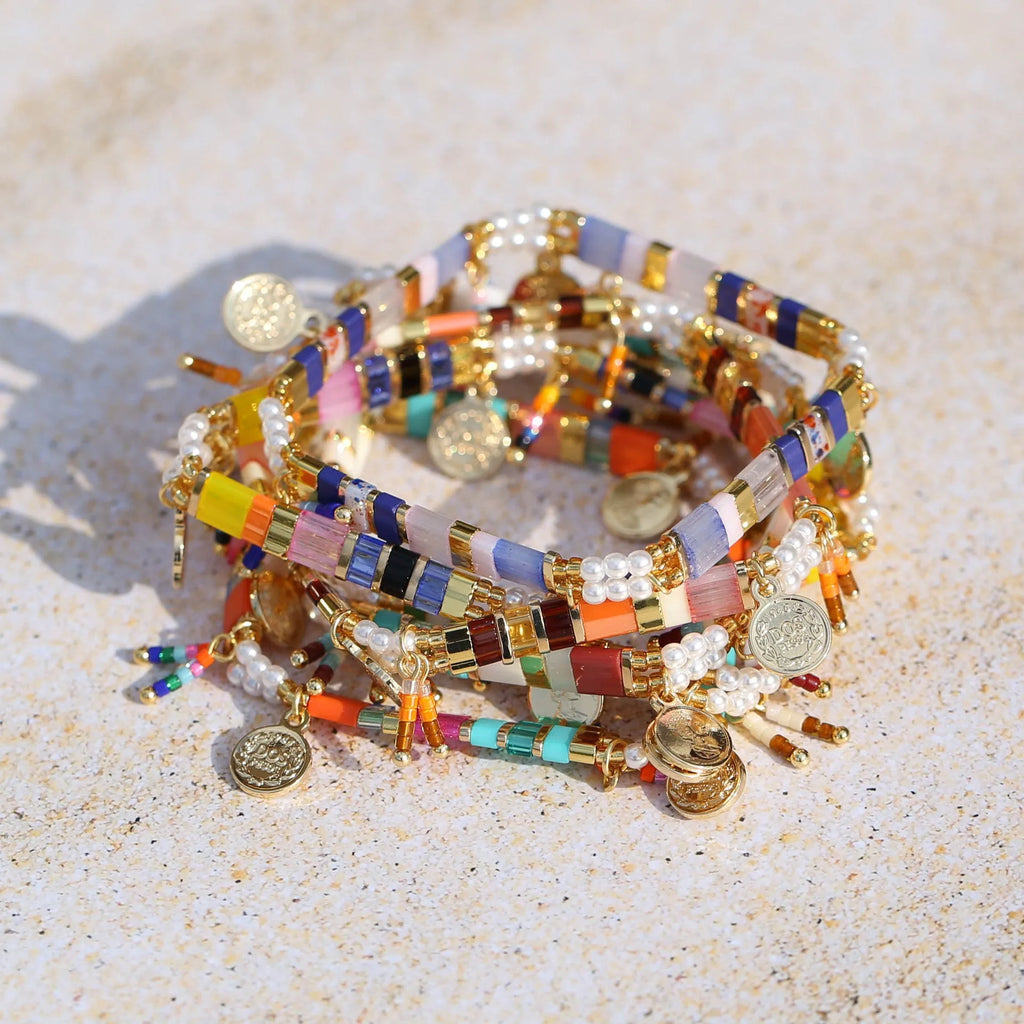 Women's bracelet with imitation pearl and coloured glass beads on wrist, showing adjustable clasp.