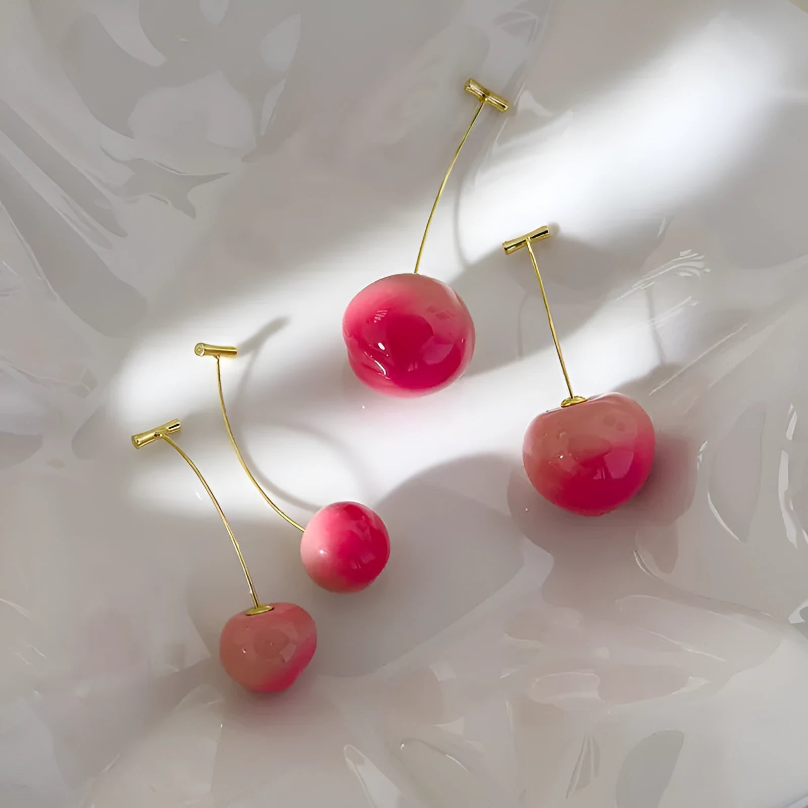 A pair of women's acrylic earrings shaped like juicy peaches on copper findings.