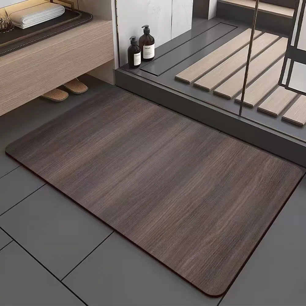 Square diatomite bathroom mat with wood grain pattern on a bathroom floor.