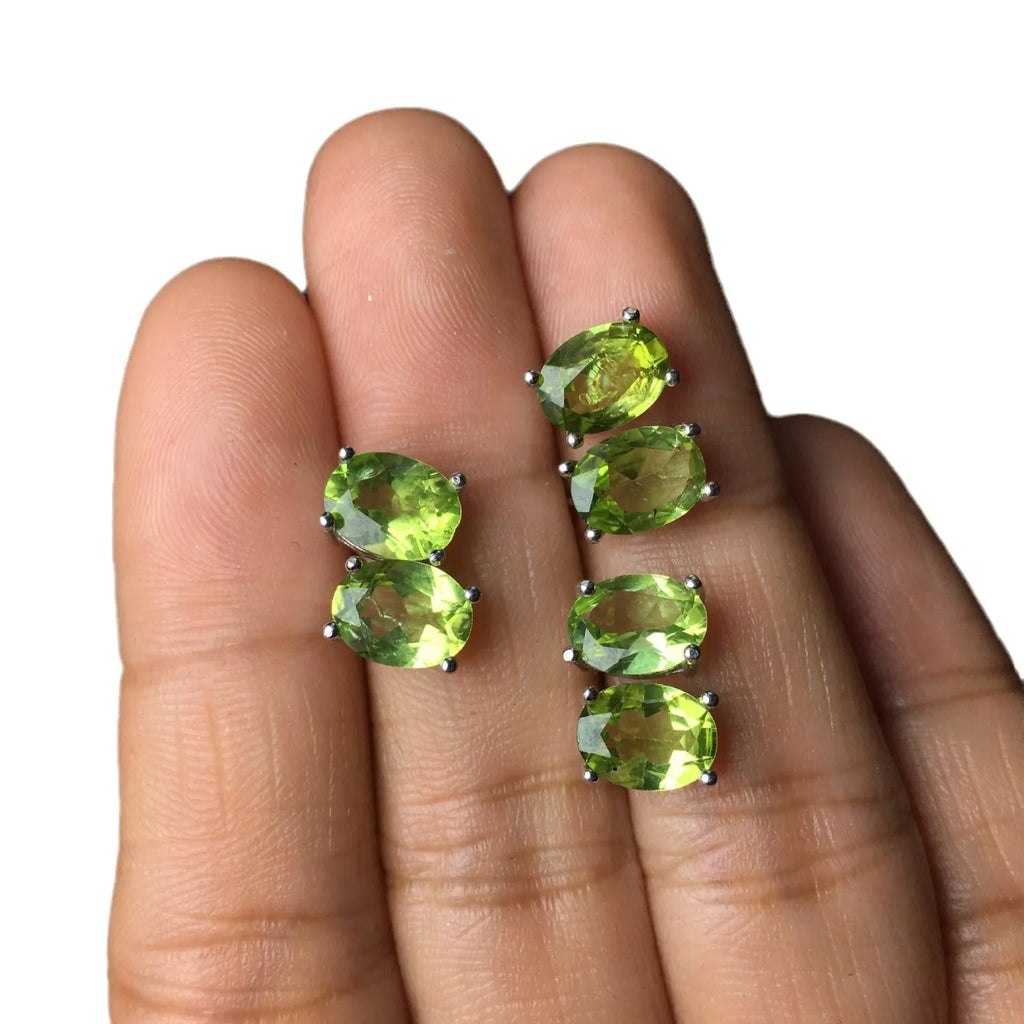 Close-up of grass green natural olivine stud earrings in S925 silver, showing ellipse-shaped stone.