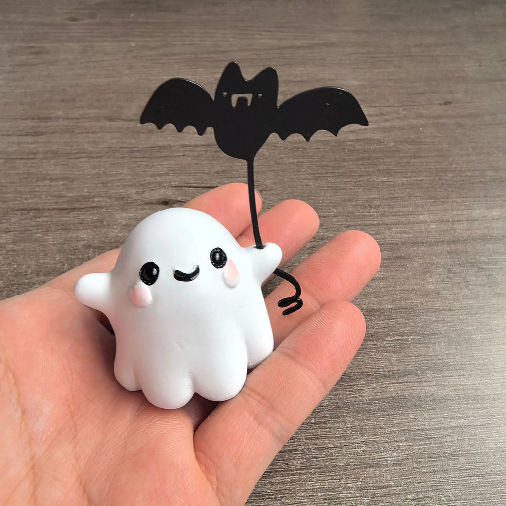 Small hand-painted resin statue of a ghost walking a dog and holding a bat, a miniature Halloween ornament.