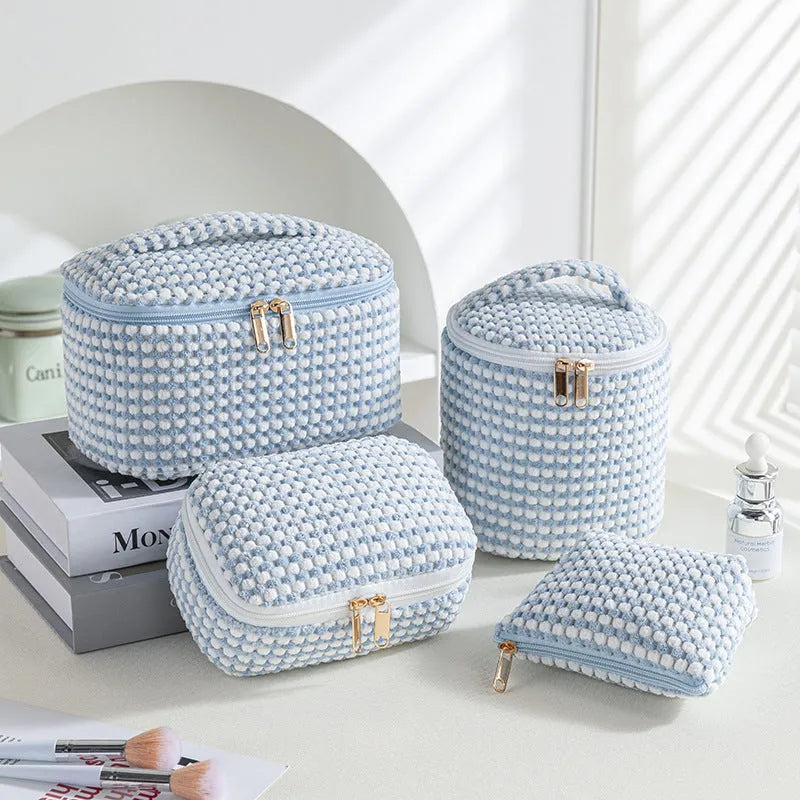 Four cube-shaped polyester makeup bags in matching colour set for travel organisation
