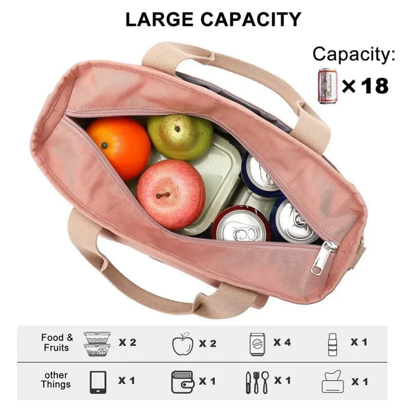 Cube-shaped pink Oxford cloth picnic bag with a removable shoulder strap and side pocket, shown on a wooden table.