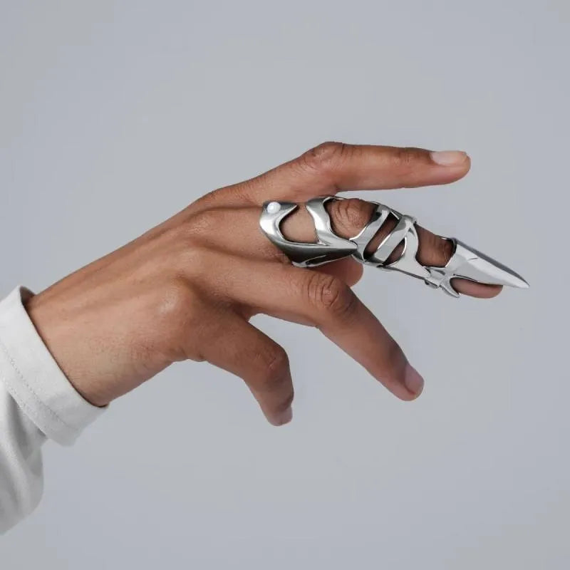 Silver metal alloy armour-style finger stall ring on a black background.