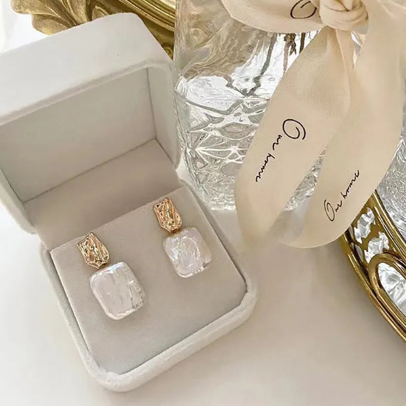 Square stud earrings with natural freshwater pearl in geometric quadrilateral setting