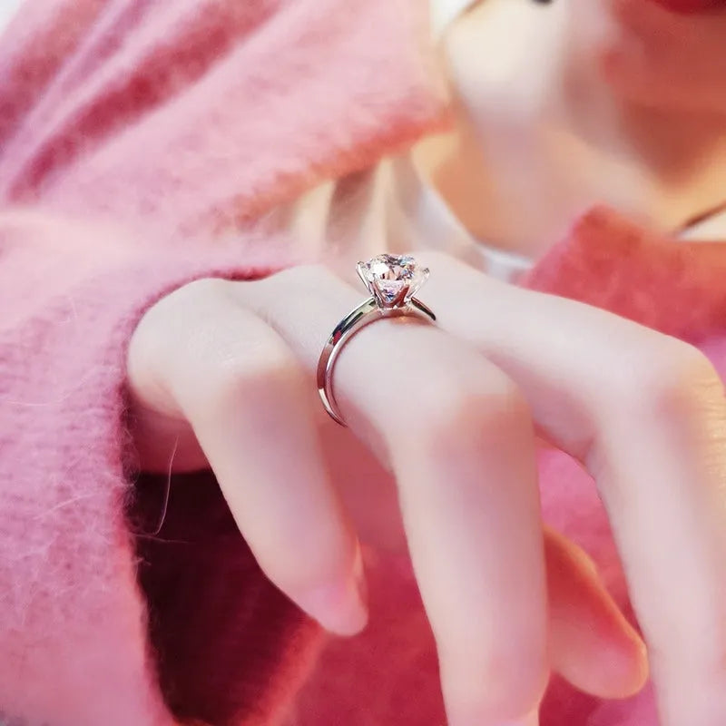 Six-claw zircon ring with geometric design and white gold plated finish shown on finger