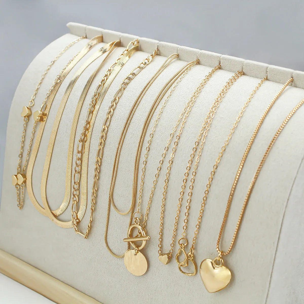 Set of 10 gold women's necklaces with adjustable chains and alloy pendants displayed in gift packaging