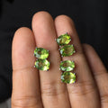 Close-up of grass green natural olivine stud earrings in S925 silver, showing ellipse-shaped stone.