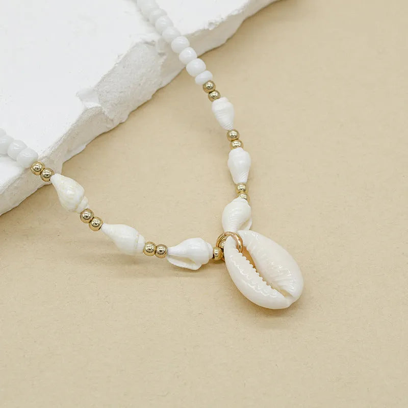 White conch shell necklace for women with a mother of pearl pendant on a regular chain.