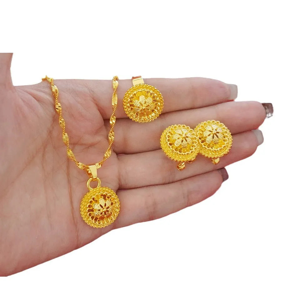 Gold-coloured three-piece jewellery set showing necklace with water wave chain, floral design earrings, and matching ring.