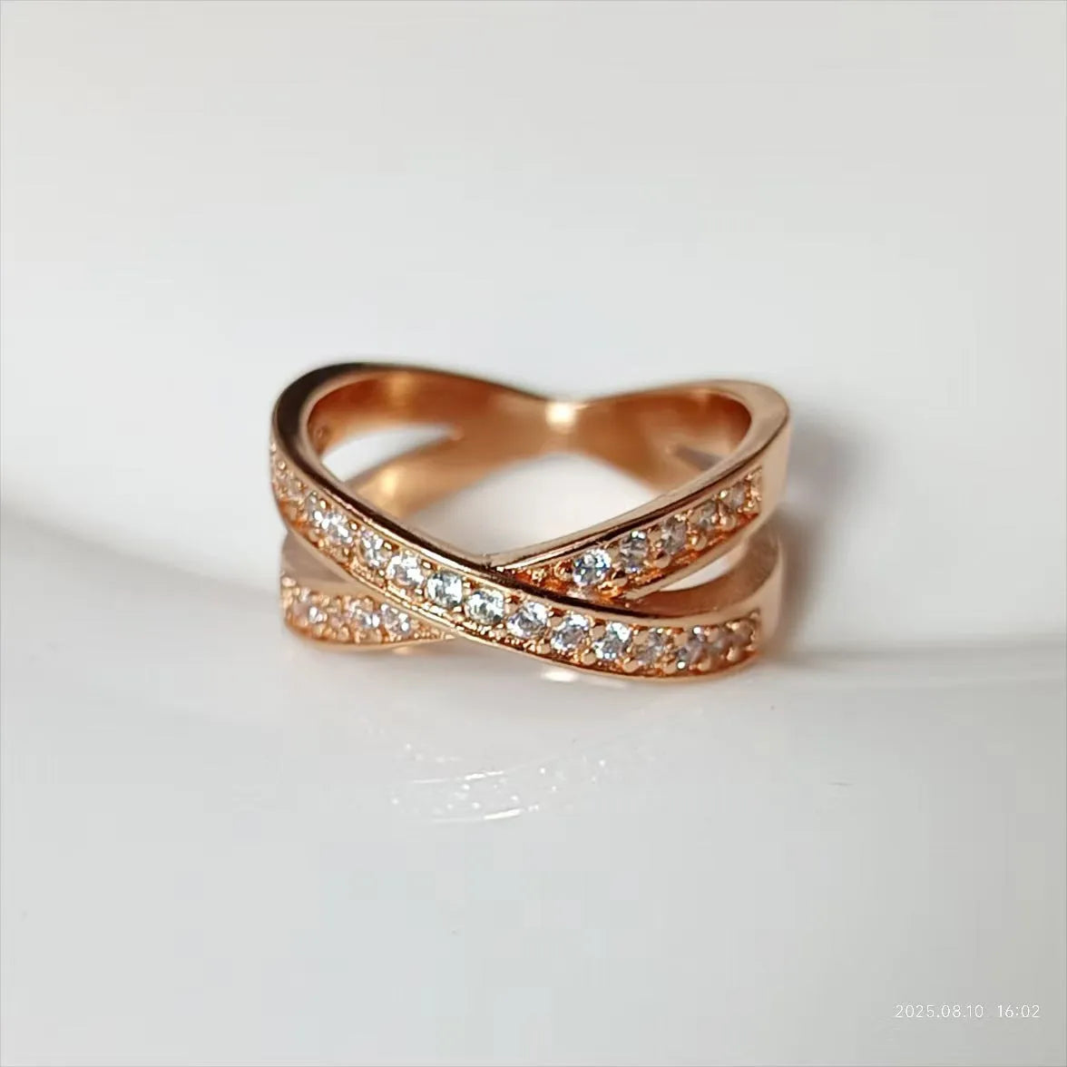 Geometric cross design ring with micro-inlaid zircon on a copper band, shown in silver and rose gold finishes.