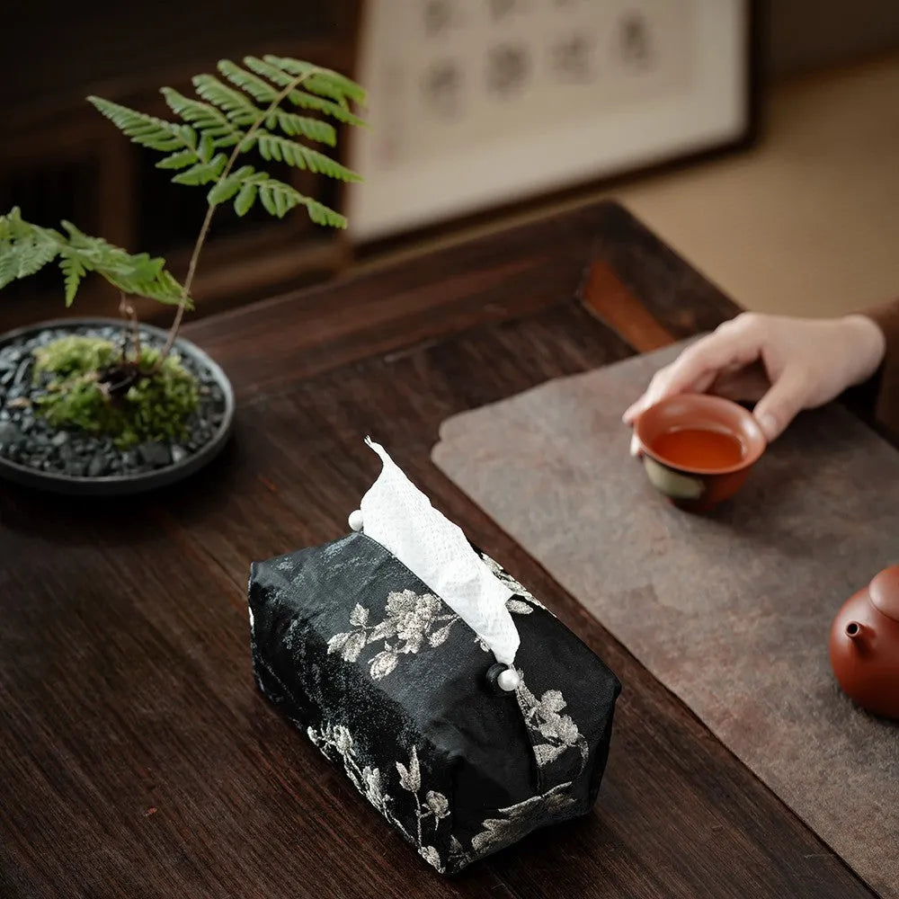 White Chinese brocade fabric tissue box with embroidered plum blossoms, shown with and without a pearl buckle clasp.
