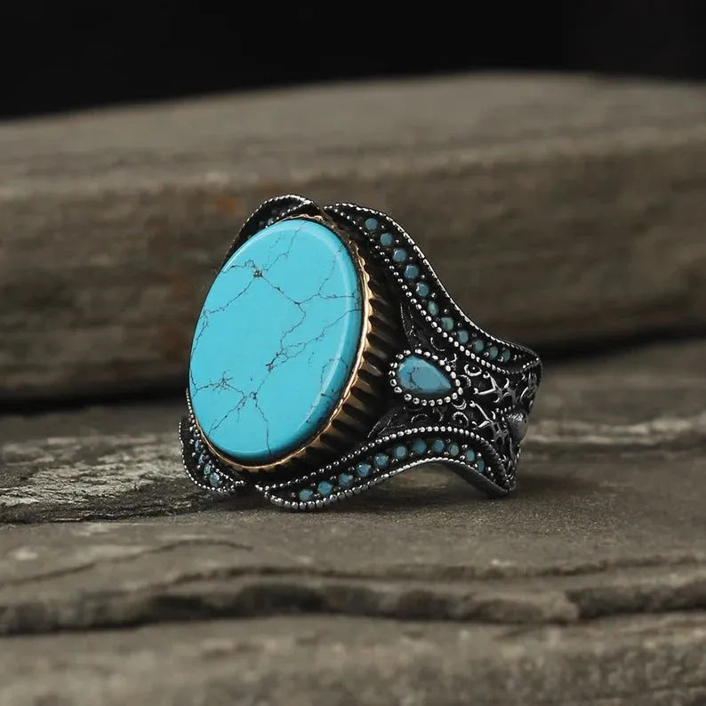 Men's simple round turquoise ring in antique silver colour on a hand.