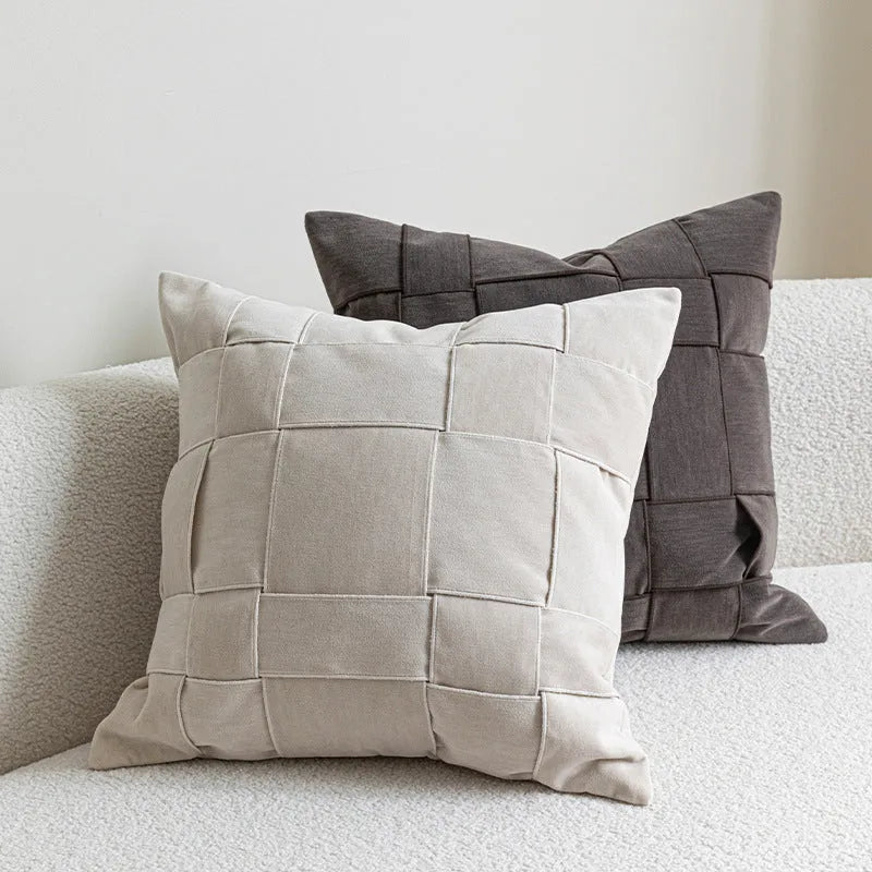 Square woven chenille pillow cushion in beige colour on a grey sofa, 50cm by 50cm size.