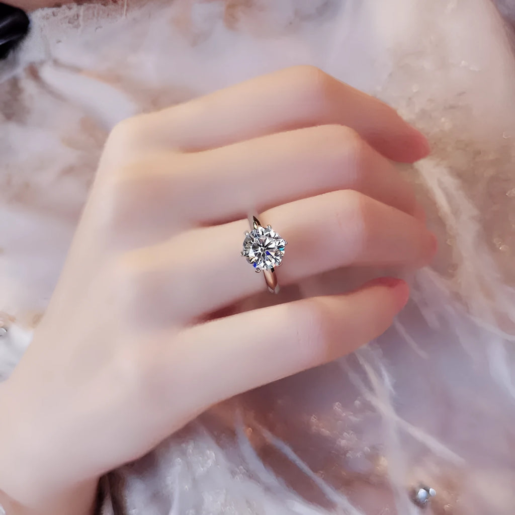 Six-claw zircon ring with geometric design and white gold plated finish shown on finger