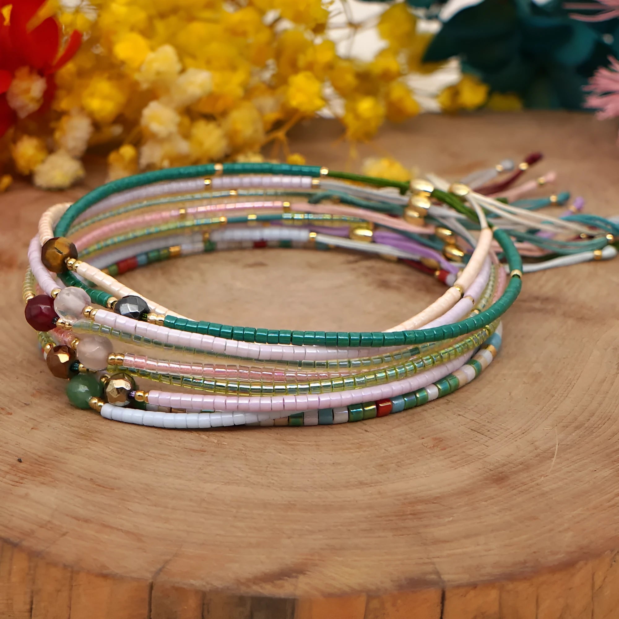 Women's handmade Bohemian bracelet with colourful glass beads in geometric shapes on a wrist.