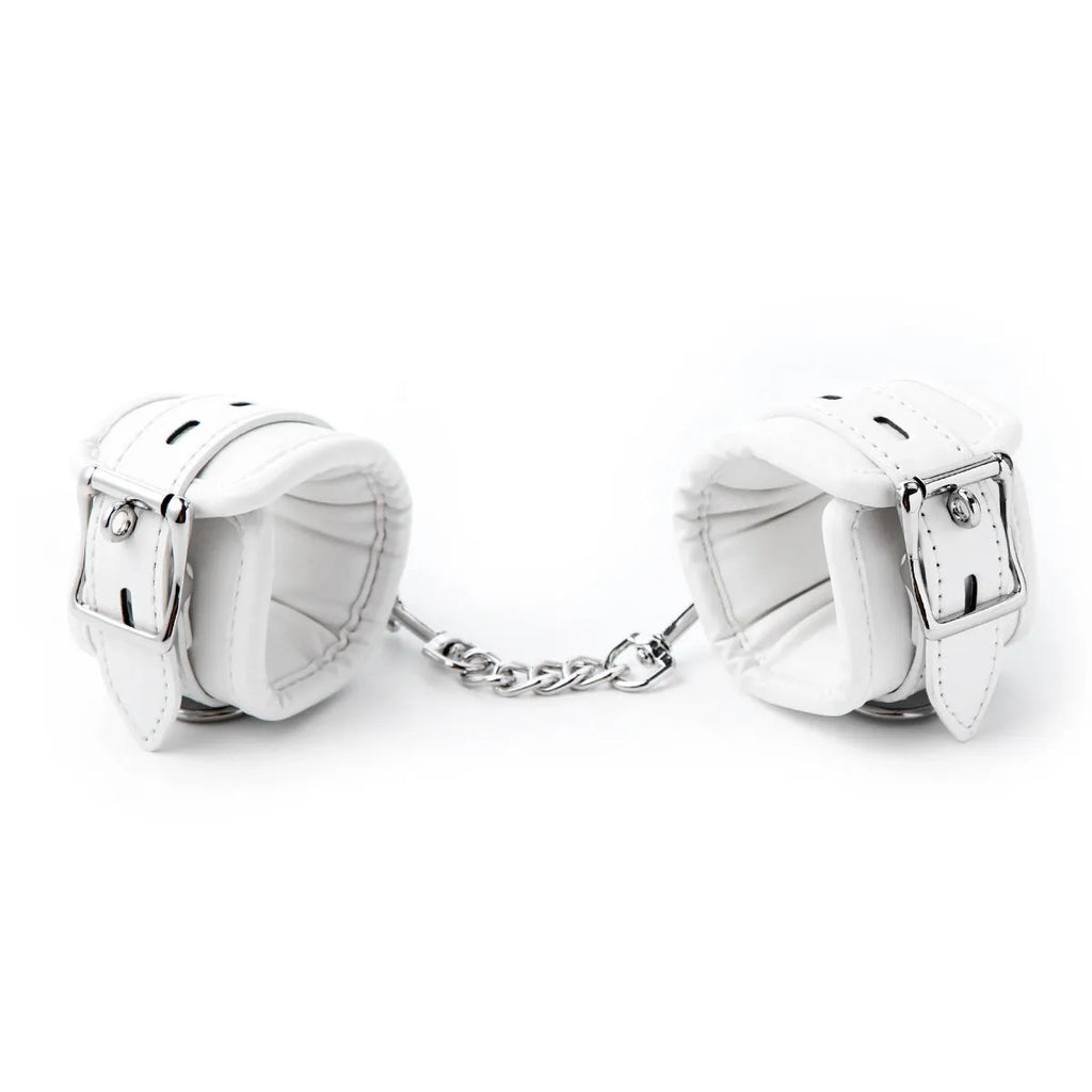 White PU sponge bondage set showing handcuffs, ankle cuffs, and a neck cuff on a neutral background.