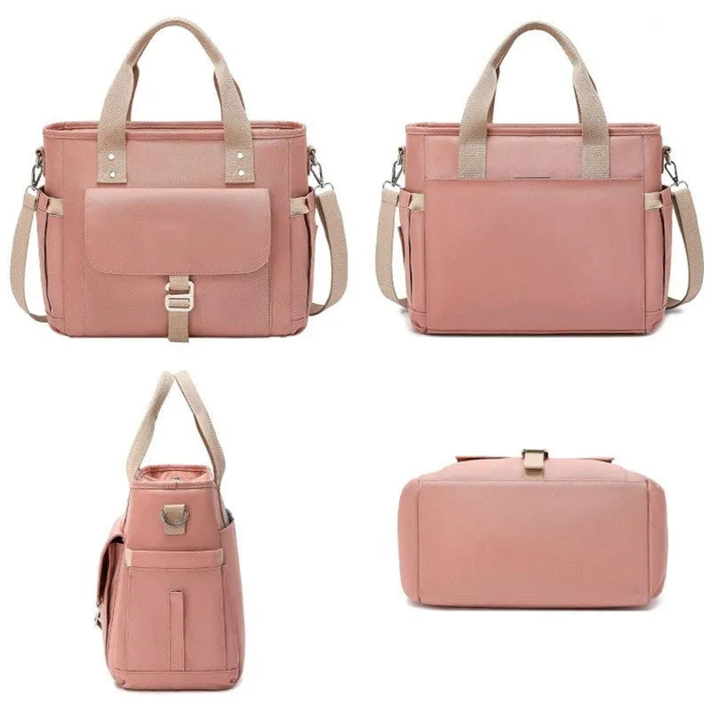 Cube-shaped pink Oxford cloth picnic bag with a removable shoulder strap and side pocket, shown on a wooden table.