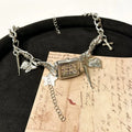 Dark multi-layer cross necklace with twin clavicle chain and textured hemp flowers chain on model