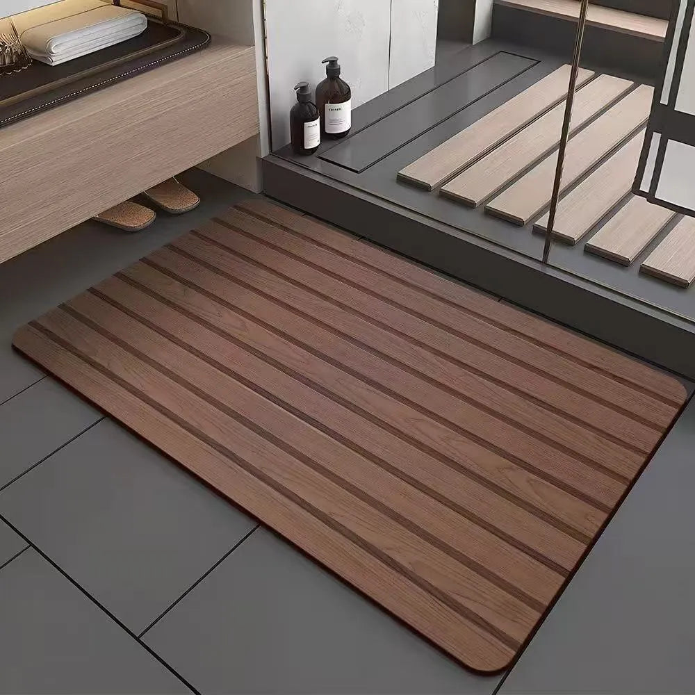 Square diatomite bathroom mat with wood grain pattern on a bathroom floor.
