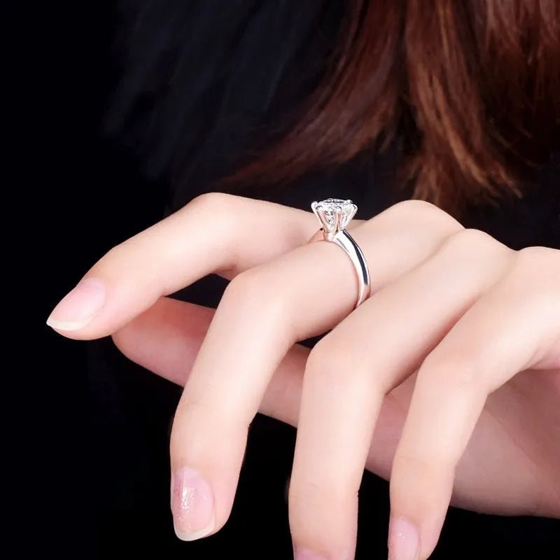 Six-claw zircon ring with geometric design and white gold plated finish shown on finger