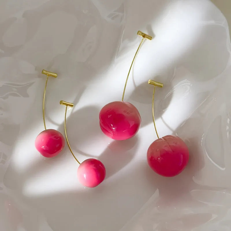 A pair of women's acrylic earrings shaped like juicy peaches on copper findings.