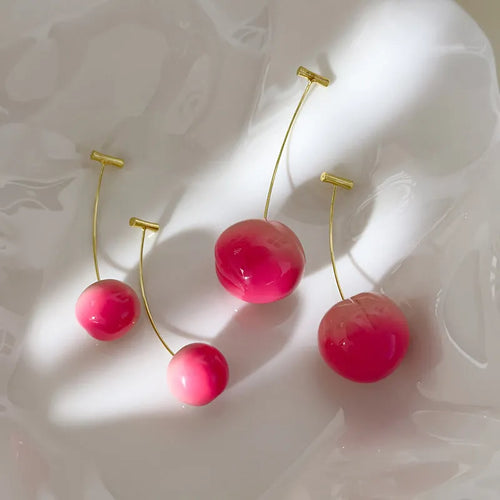 A pair of women's acrylic earrings shaped like juicy peaches on copper findings.