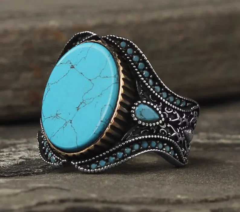 Men's simple round turquoise ring in antique silver colour on a hand.