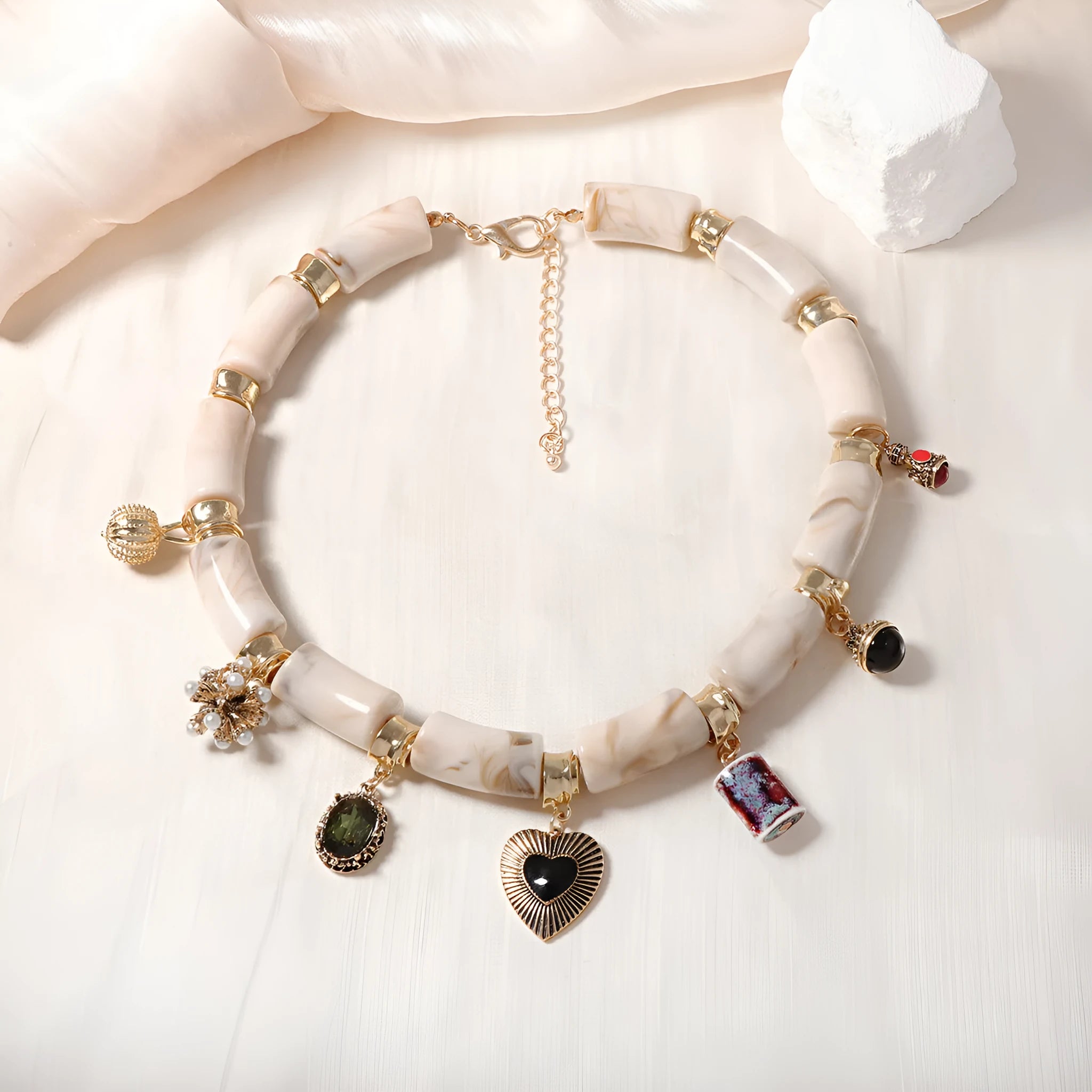 Close-up of a women's resin necklace with a heart-shaped pendant containing a bamboo detail and an electroplated metallic finish.