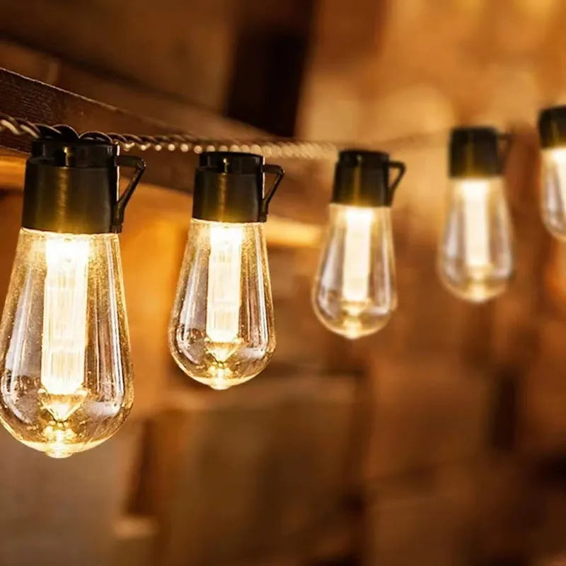 Waterproof outdoor string lights with retro glass bottle-shaped lamps hanging from a green wire.
