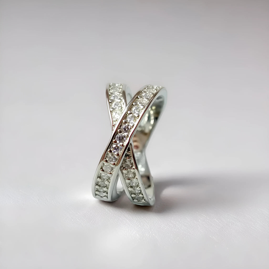 Geometric cross design ring with micro-inlaid zircon on a copper band, shown in silver and rose gold finishes.