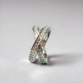 Geometric cross design ring with micro-inlaid zircon on a copper band, shown in silver and rose gold finishes.