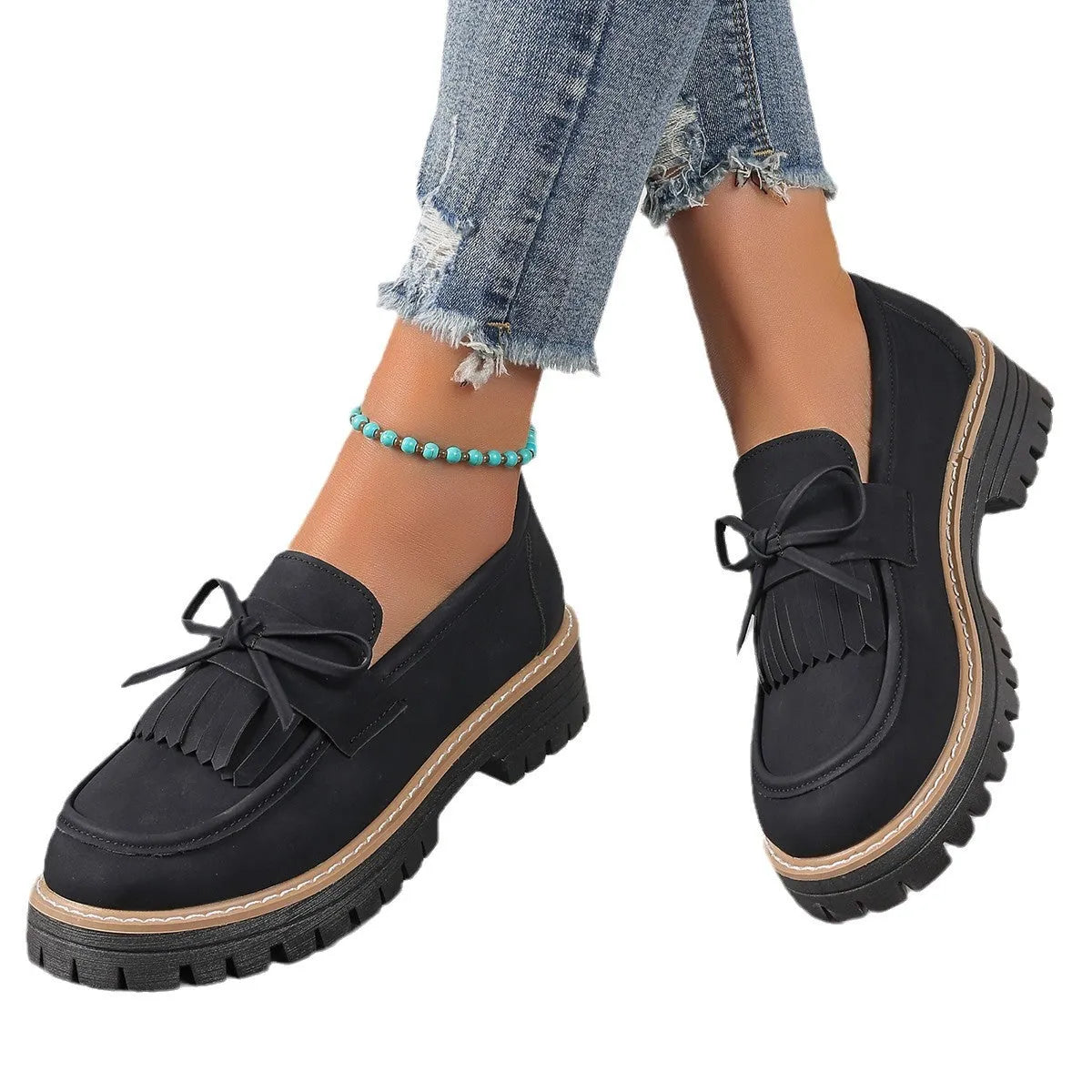 Women's black plus size loafers with a tassel and bowknot decoration and a chunky rubber sole.