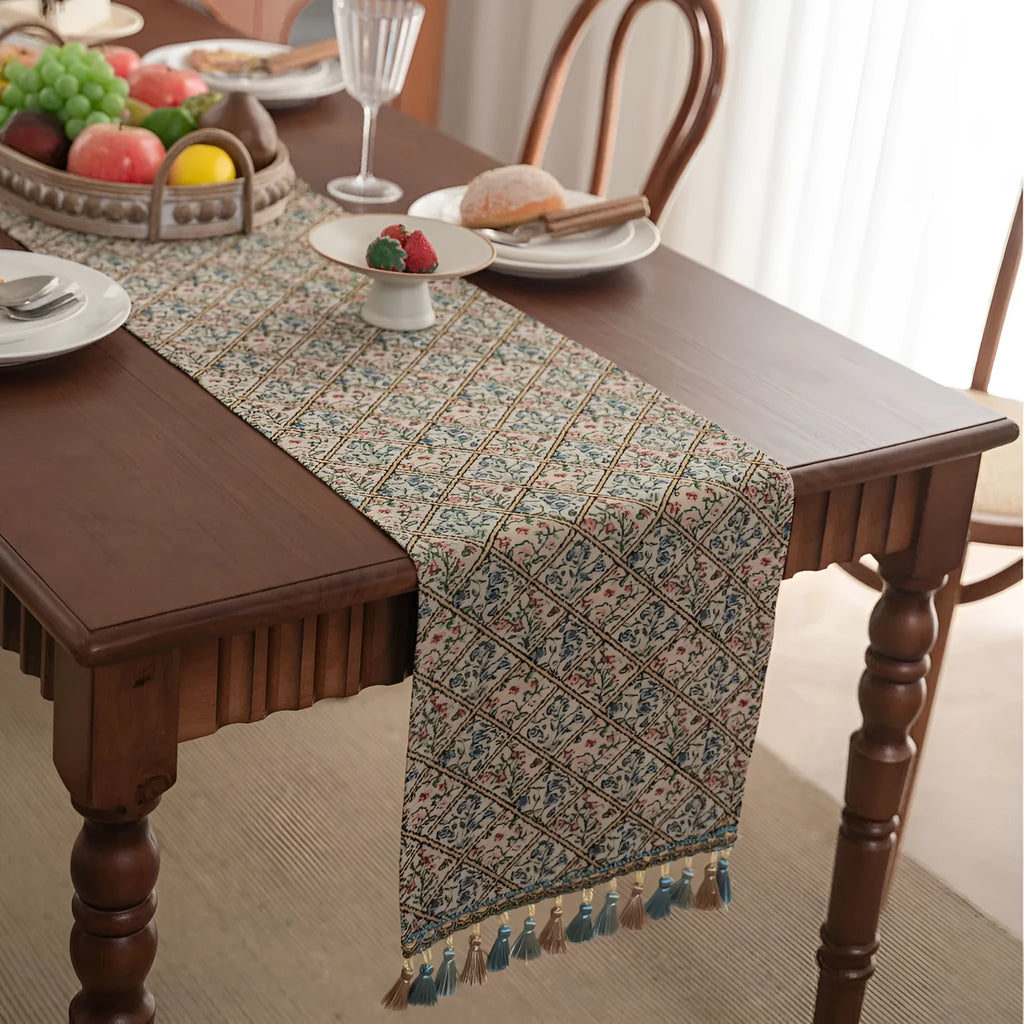 Nordic jacquard table runner with tassel trim in dark blue striped pattern laid on a wooden table.