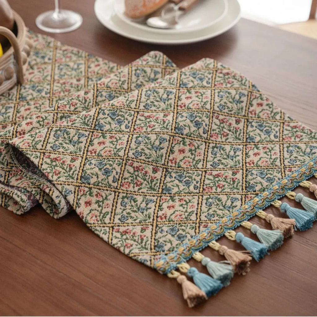 Nordic jacquard table runner with tassel trim in dark blue striped pattern laid on a wooden table.