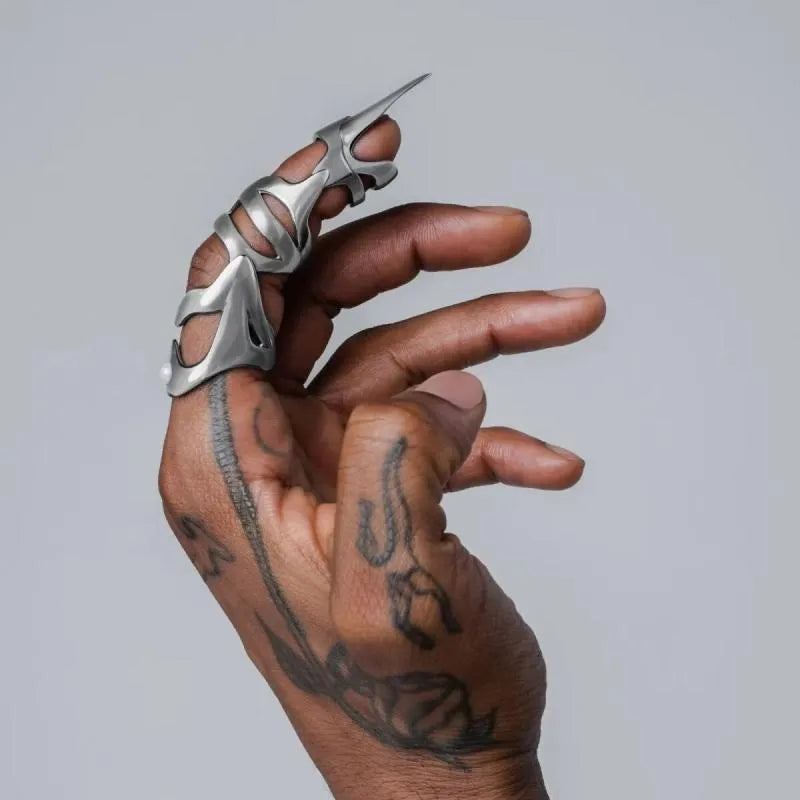 Silver metal alloy armour-style finger stall ring on a black background.