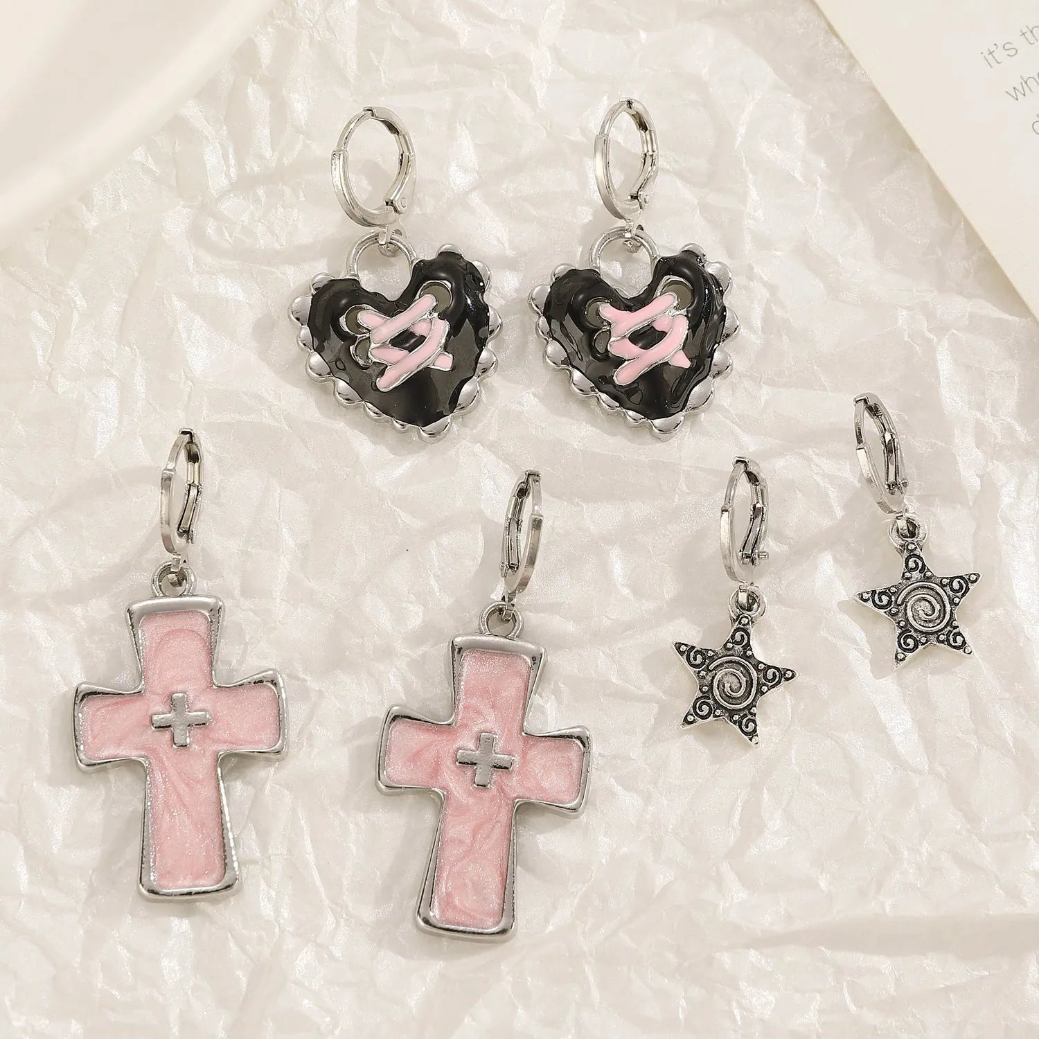 Women's classic alloy earrings showing cross, heart, and animal designs in white, black, and silver colours