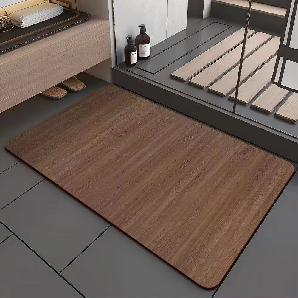 Square diatomite bathroom mat with wood grain pattern on a bathroom floor.