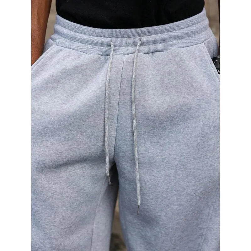 Men's high-waisted straight-leg casual trousers in a neutral colour, showing the cropped length and elasticated fit.