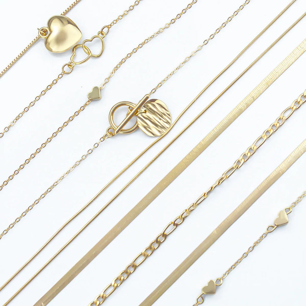 Set of 10 gold women's necklaces with adjustable chains and alloy pendants displayed in gift packaging