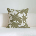 Green striped and botanical patterned hotel sample pillow with tassels on a bed display.