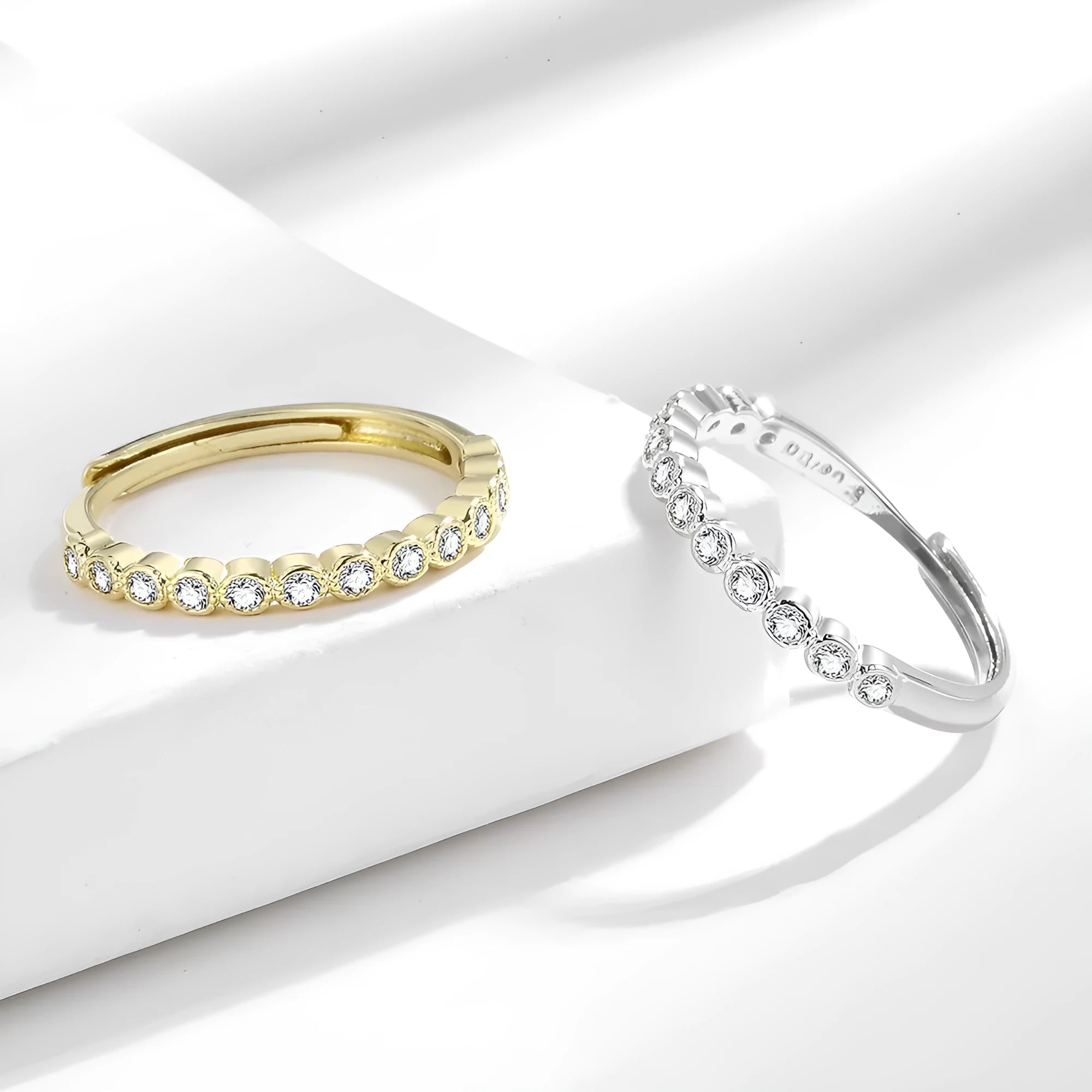 Women's geometric diamond tail ring in electroplated copper, shown in white gold colour and yellow gold colour finishes.