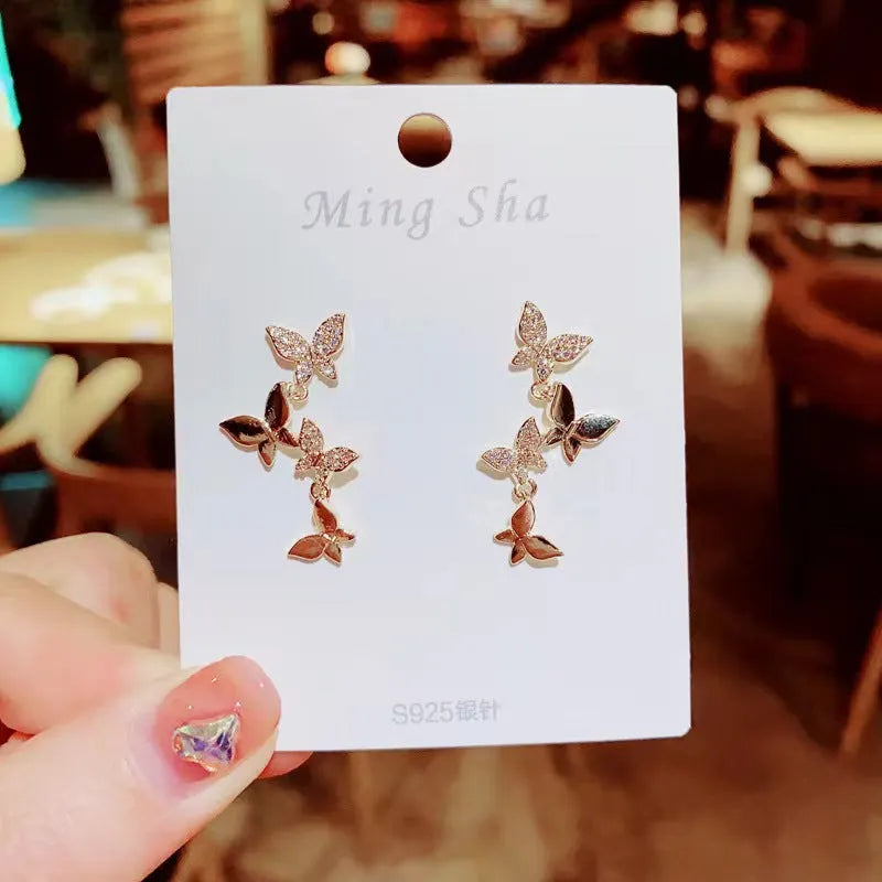 Women's copper butterfly drop earrings with four-butterfly design and gold-coloured finish